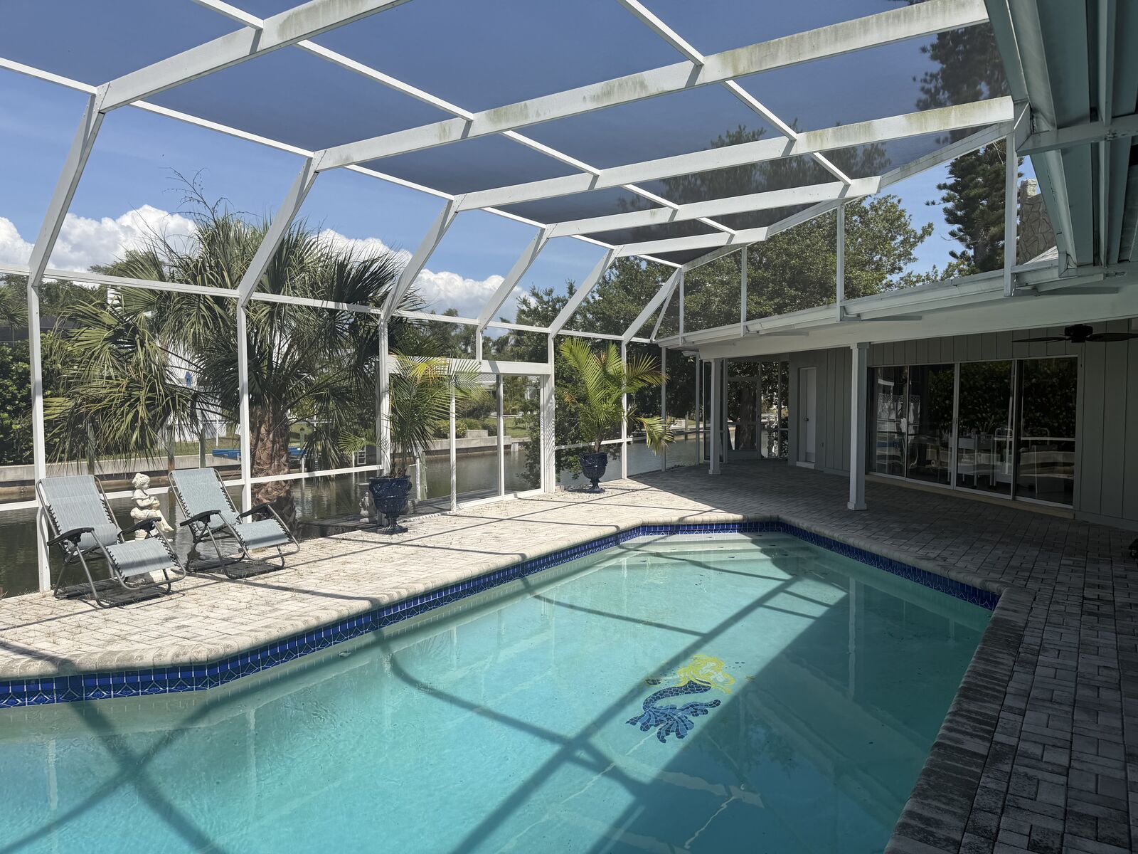 Screened pool with canal and deep-water dock beyond