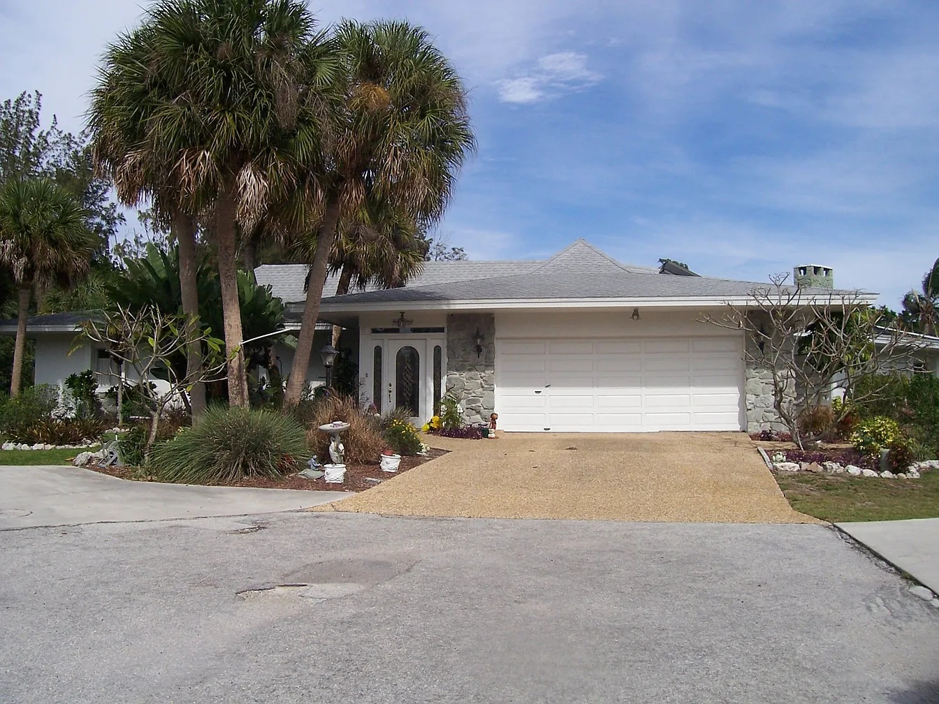 Front view of 6937 Midnight Pass Rd, a Siesta Key Florida waterfront home framed by palm trees